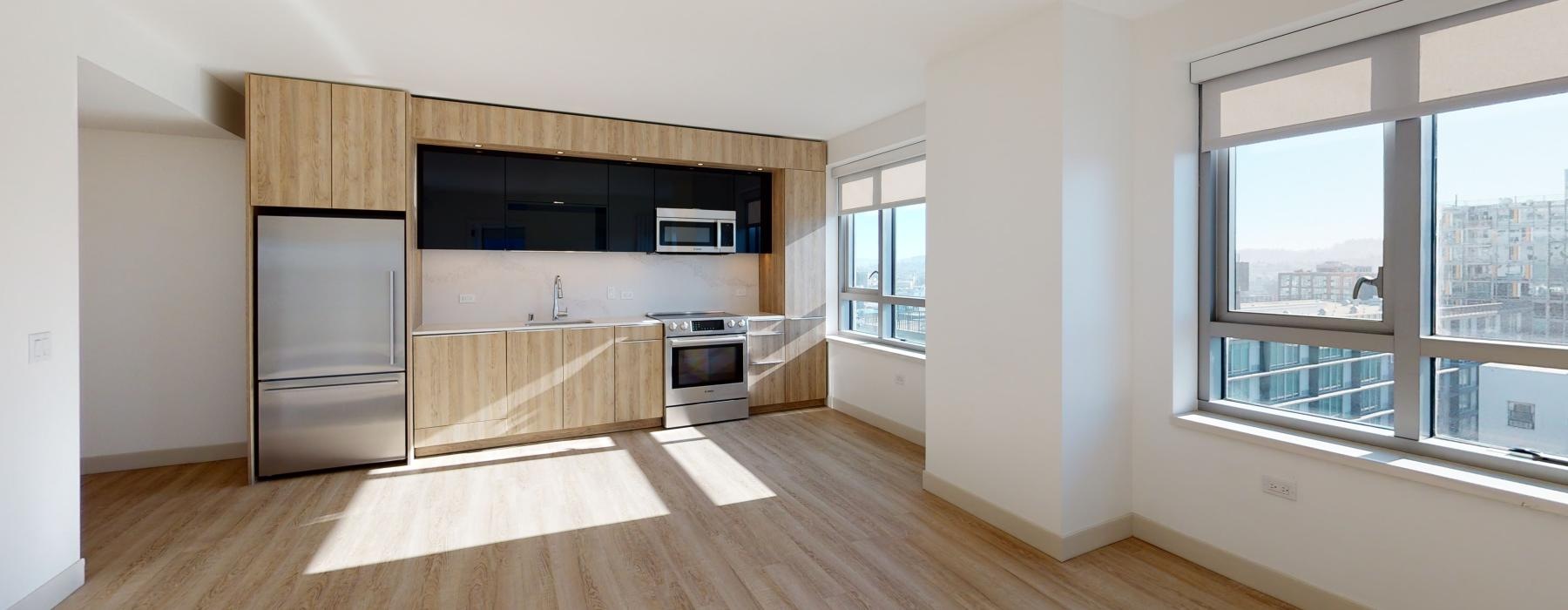 a kitchen with a wood floor and natural lighting