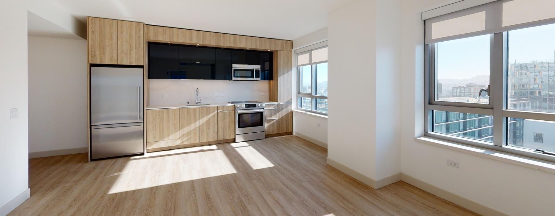 a kitchen with a wood floor and natural lighting