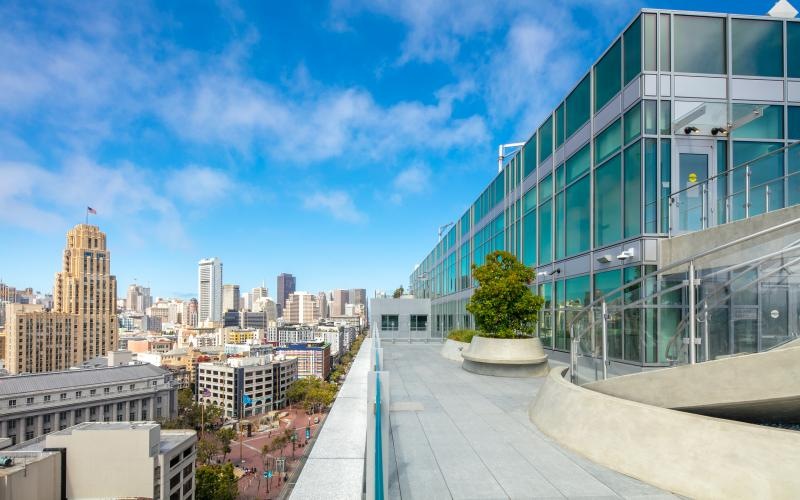 a building with a walkway and a city in the background